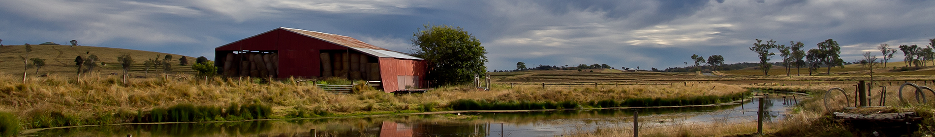 Panarama image of a farm shed and dam